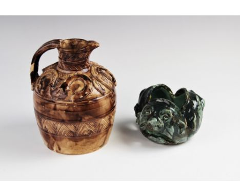 An Arts & Crafts studio pottery pierced vessel, modelled as three grotesque heads, glazed in mottled greens, signed to base '