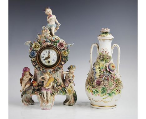 A Sitzendorf porcelain figural mantel clock, 19th century, the rococo shaped clock case extensively encrusted with floral bou