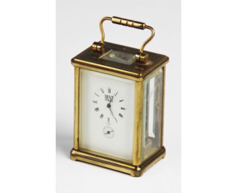 An early 20th century brass cased French carriage clock, with a visible escapement above the 5cm white enamelled dial centred