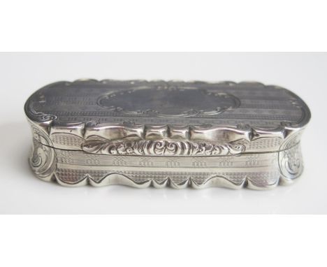 A Victorian silver snuff box, maker Nathanial Mills, Birmingham 1857, of shaped oval outline, with concave sides having engin