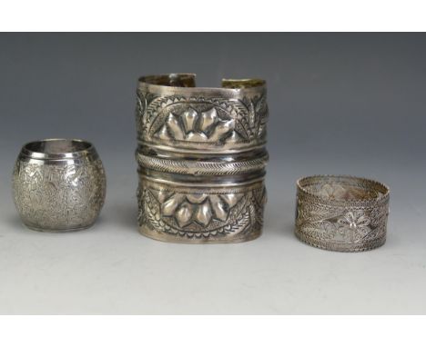 A Persian Silver Bangle with embossed fish decoration (7.5cm long, 112.5g), a Persian silver napkin ring and a silver filigre