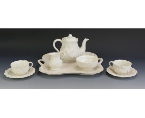 A Minton bisque porcelain tête-à-tête set, comprising two cups, saucers, cream jug, sugar basin, teapot and tray with moulded