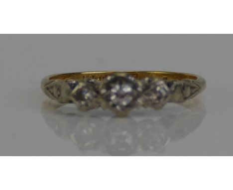 An 18ct Gold and Diamond Three Stone Ring, c. 2.4mm principal brilliant round cut illusion set in platinum, size M.25, 2.16g 