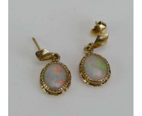A Pair of Opal Pendant Earrings in a precious yellow metal setting, 22.5mm drop, KEE tests as 14K, 2.2g.  UNLESS OTHERWISE ST