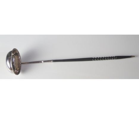 A George III silver punch ladle, all marks worn, mounted on a spiral twist ebonised handle. 37cm long. 