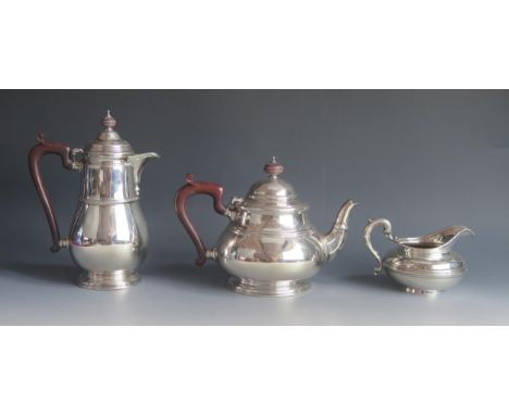 A matched three-piece silver tea service, various makers and dates, of ovoid form with ribbed girdle, , includes teapot, hot 