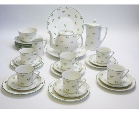 A bone china part tea service, with green clover leaf decoration, includes teapot, hot water jug, cream jug, sugar basin, cup