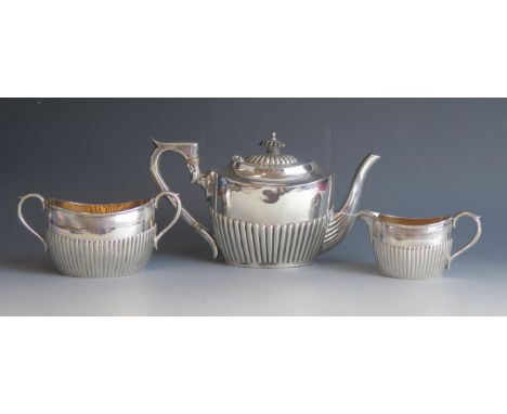A matched silver three-piece tea service, various makers and dates, of oval form with half reeded decoration, total weight of