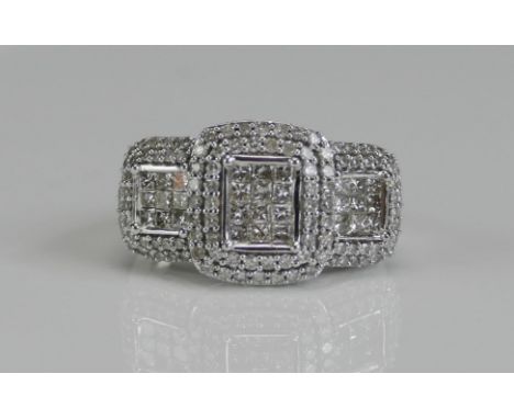 An 18ct White Gold and Diamond Panel Ring, the central elements invisibly set princess cuts and enveloped by claw set brillia