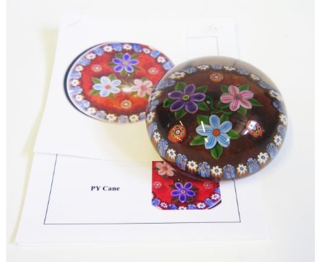 Paul Ysart, a domed glass paperweight three flowers within a millefiori border, initialled cane, 10cm diameter, with Sweetbri