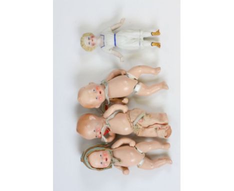 Three plaster of paris small baby dolls with free-moving arms and legs, height approximately 11cm together with a hand painte