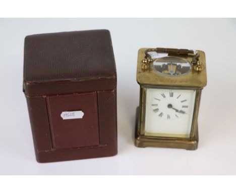 A brass carriage clock, white enamel dial with black Roman numerals and hands, height approximately 11cm excluding handle tog