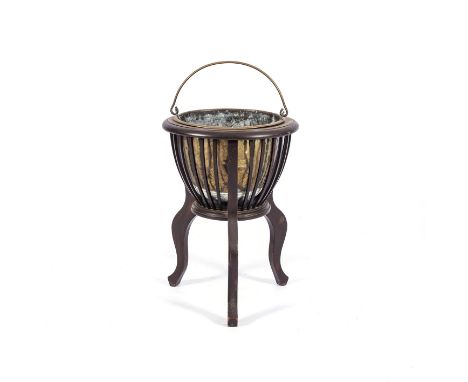 A BRASS POT AND MAHOGANY STAND, 19TH CENTURY Wooden tripod stand enclosing a brass pot,53cm high, 38cm wide 
