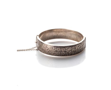 A SILVER BANGLE Oval sterling silver, on a hinge, 18mm wide, with engraving on the top section 