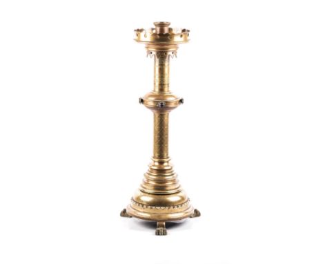 A BRASS PRICKET ALTER STICK 19TH CENTURY The moulded rim on knobbed stem and shapedcircular base, raised on paw feet, 70cm hi