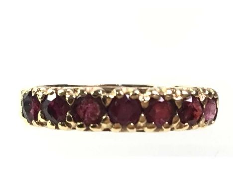 RUBY DRESS RING, IN NINE CARAT GOLD  set with a row of seven round stonesQty: 2.8g