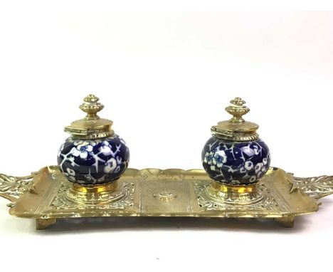 VICTORIAN BRASS DESK STAND, AND A FURTHER BRASS INKWELL the first with twin Chinese style ceramic inkwells, each marked 1090 