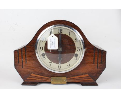 Art Deco style oak mantel clock, the arched case with engraved line decoration and brass presentation plaque dated 1935, the 