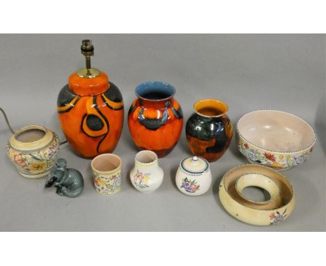 A collection of Poole pottery, including a standard lamp, various vases, model of a seal and other similar pottery pieces. 