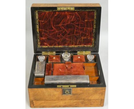 A Victorian mahogany travelling vanity case, the hinged cover opening to reveal a drop down mirror, two silver plated and gla