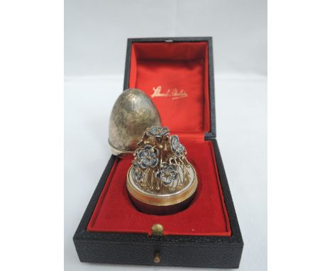 A Stuart Devlin silver gilt surprise egg for year 1979, Limited Edition no: 170 containing a spray of blue enamelled flowers 