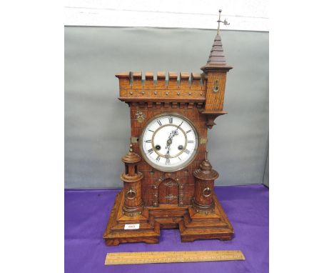A late 19th century oak mantel clock modelled as Continental castle with battlements, turret and flag including brass appliqu