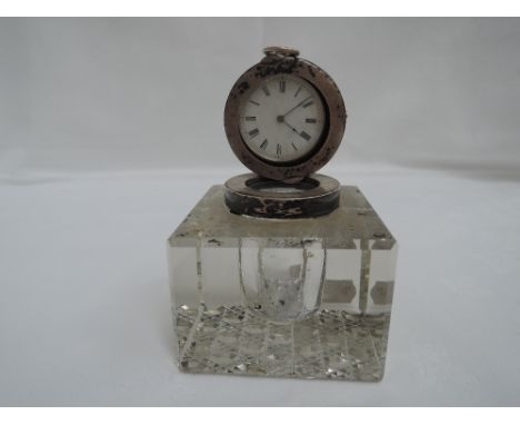 An Edwardian cut glass inkwell of square form having a silver hinged top containing a key wound HM silver pocket watch having