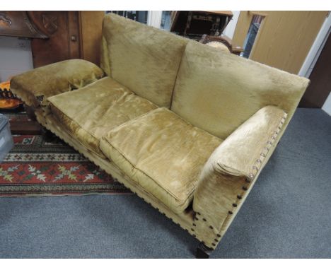 An early 20th century lounge suite comprising drop end settee and armchair upholstered in button down gold coloured upholster