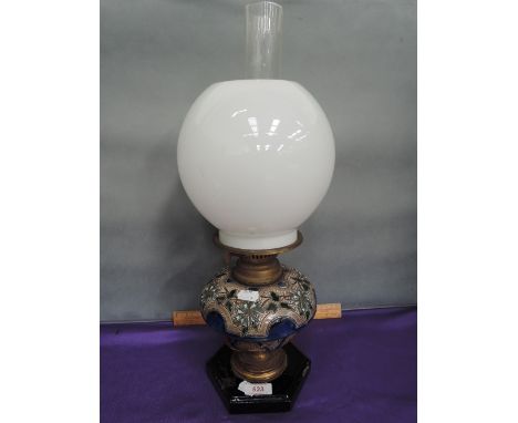 A Victorian Doulton Lambeth earthenware oil lamp having typical glazed decoration on brass and marble base, with glass globe 