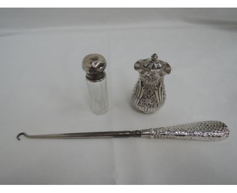 A Victorian silver pepperette of oval baluster form having frilled rim to pierced lid and extensive repousse decoration, Birm