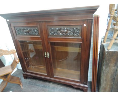 A re-furbished late Victorian mahogany bookcase having glass and carved panels, on bracket feet