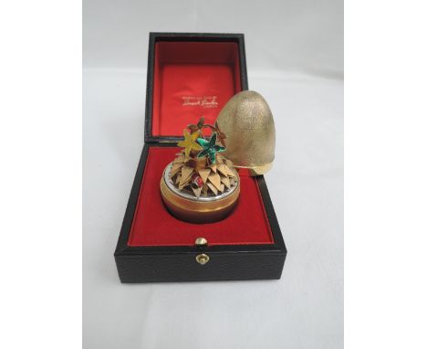 A Stuart Devlin silver gilt surprise egg for year 1976, Limited edition no 170, containing four coloured enamel flowers and a