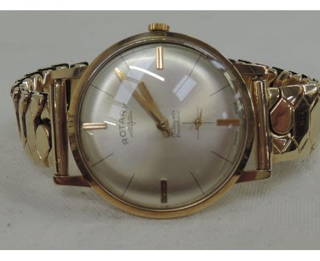 A gents 9ct gold wrist watch by Rotary having baton numerals and subsidiary seconds on a plated stretch strap