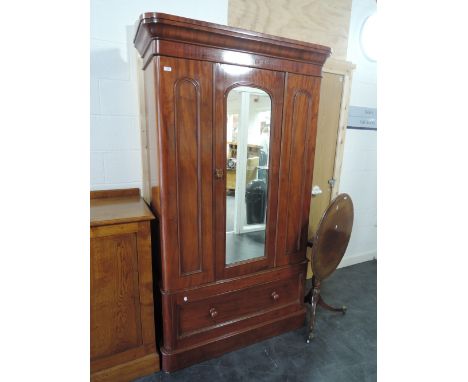 A mid Victorian mahogany wardrobe having central mirror arch door and drawer under