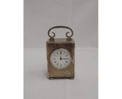 A small Edwardian silver carriage clock of plain rectangular form containing a French movement and having a swing scroll hand