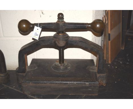 *Bookpress. A cast iron bookpress,  by J. Carter, Lime Street, London, finished in black, with brass handle ends and finial, 