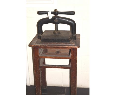 *Bookpress. A cast iron bookpress,  finished in black, with brass merchant disk of Matthews Drew & Co., Wholesale Stationers,