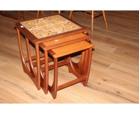 A nest of three mid century teak tile topped tables, 52 cm x 50 cm x 49 cm. CONDITION REPORT: Very minor scratch to top other