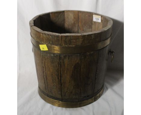 A Coopered oak plant with brass ring handles, 23 cm x 24 cm. CONDITION REPORT: The oak splat's are slightly loose and the bas