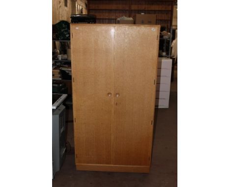 A Merrydew light oak double wardrobe, 175 cm x 90 cm x 56 cm.  CONDITION REPORT: Some losses to the veneer to the right-hand 