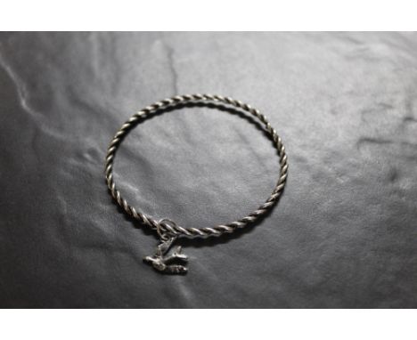 A white metal rope twist bangle, with suspended swallow charm. Gross weight 7 grams.  CONDITION REPORT: The bangle has been o