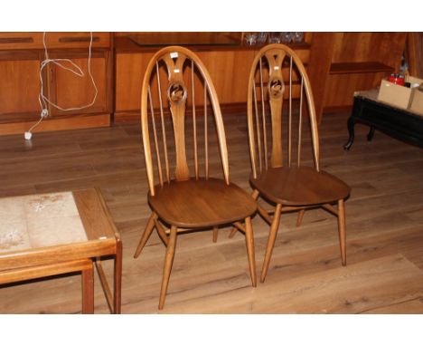 A pair of ercol swan design high hoop back chairs, 100 cm with a seat height of 42 cm. CONDITION REPORT: Each in good conditi