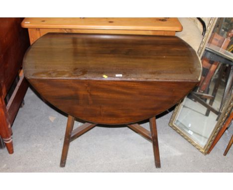 An Ercol dark elm drop leaf dining table, with rounded flaps and X form stretcher, 71 x 108 x 63 cm. CONDITION REPORT: Genera