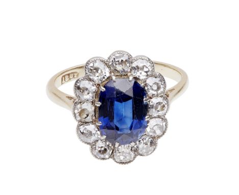 A sapphire and diamond set cluster ring    claw set with an oval cut sapphire, in a border of old-round cut diamonds, to a pl