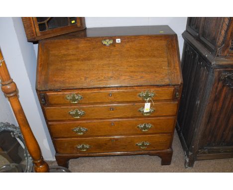 A Georgian oak bureau, the fall-flap opening to reveal a fitted interior with drawers and pigeon holes, above four graduating