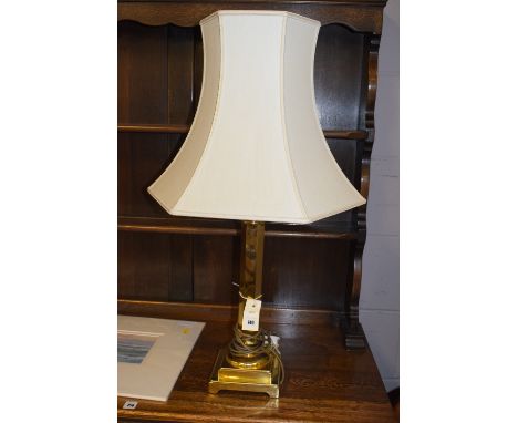 A large modern brass hexagonal column table lamp on stepped square-shaped plinth base, fitted a cream coloured shade, approxi