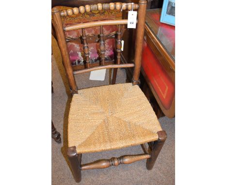 An early 20th Century elm single dining chair, with bobbin turned top rail and rushwork seat.