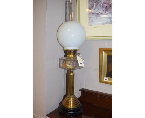 A 19th Century oil lamp with opaque glass shade and clear glass reservoir on brass support.