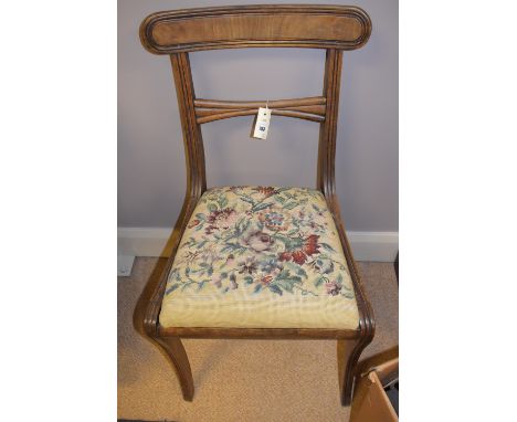 A pair of early 19th Century mahogany dining chairs, curved cresting rails on reeded supports, fitted drop-in seats upholster