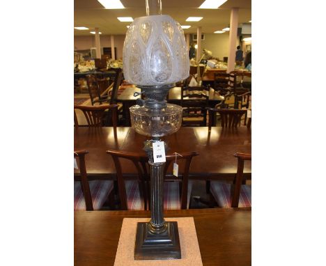 A 19th Century brass oil lamp the shade with etched bird and floral designs clear glass reservoir above corinthian column.